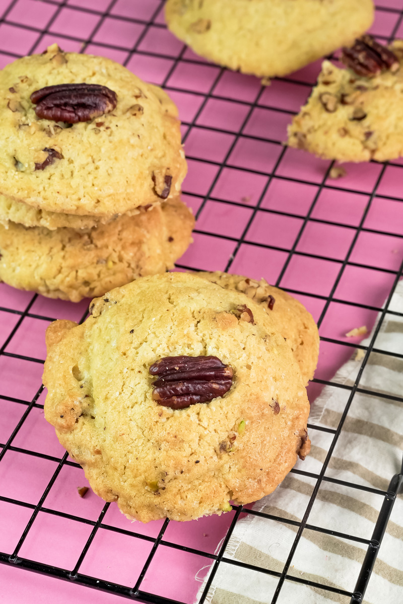 Stack of Pecan Pie cookies next to a single cookie on a wire rack