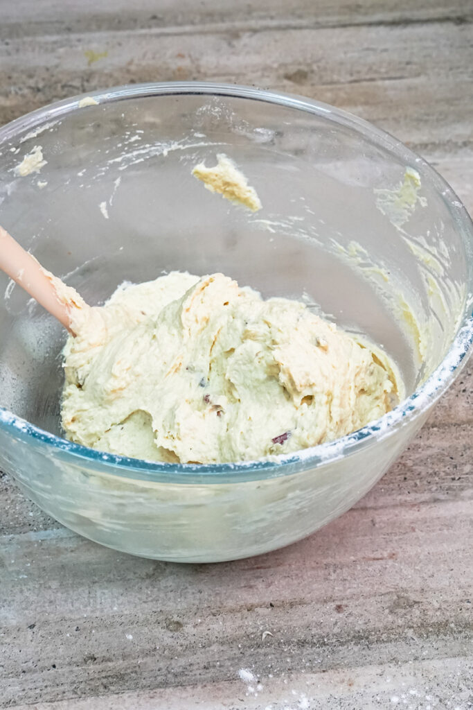 Stirring chopped pecans into the cookie dough with a spatula