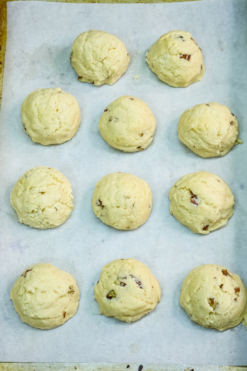 Unbaked Mexican wedding cookies arranged on baking sheet before oven