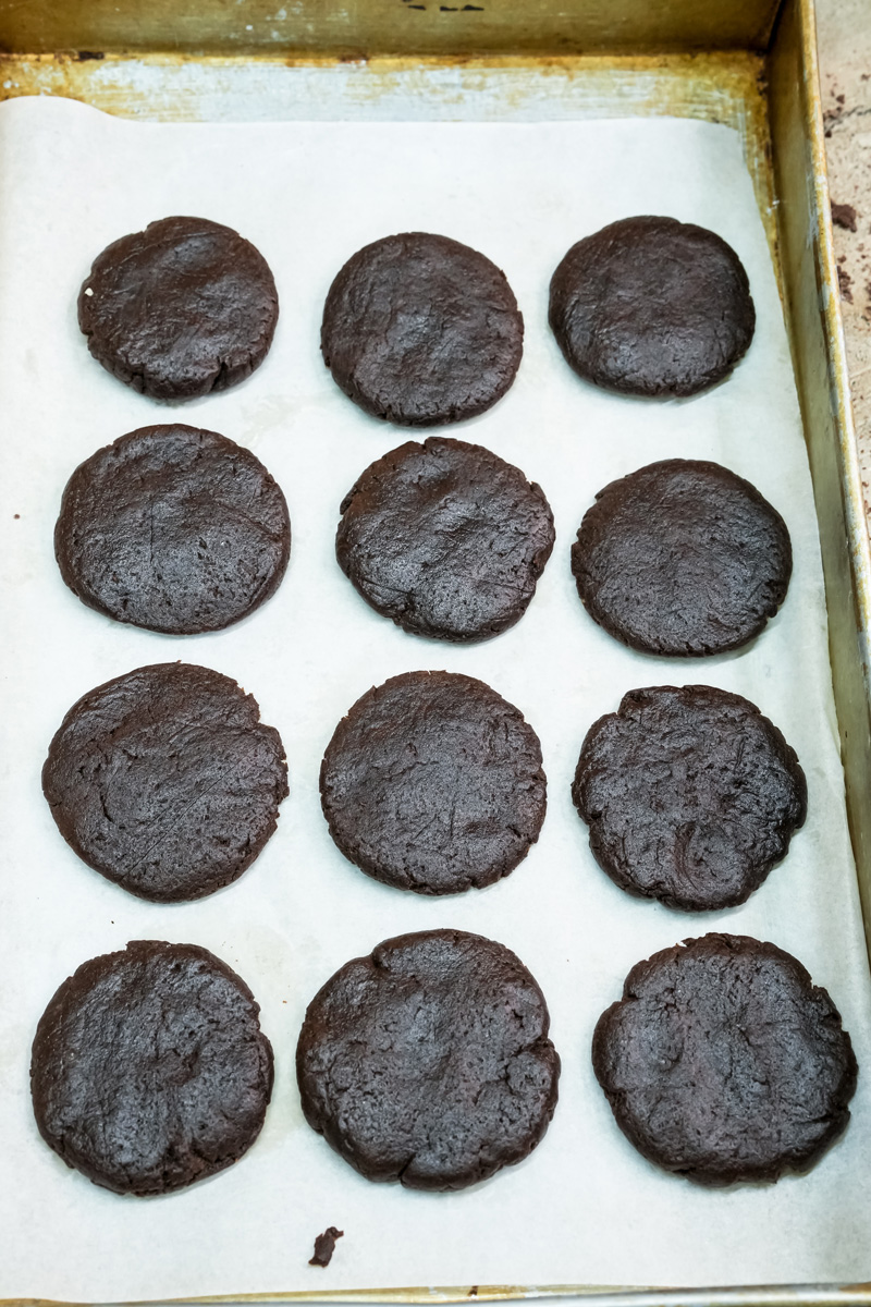 Unbaked homemade Oreo cookies on a baking sheet with parchment paper