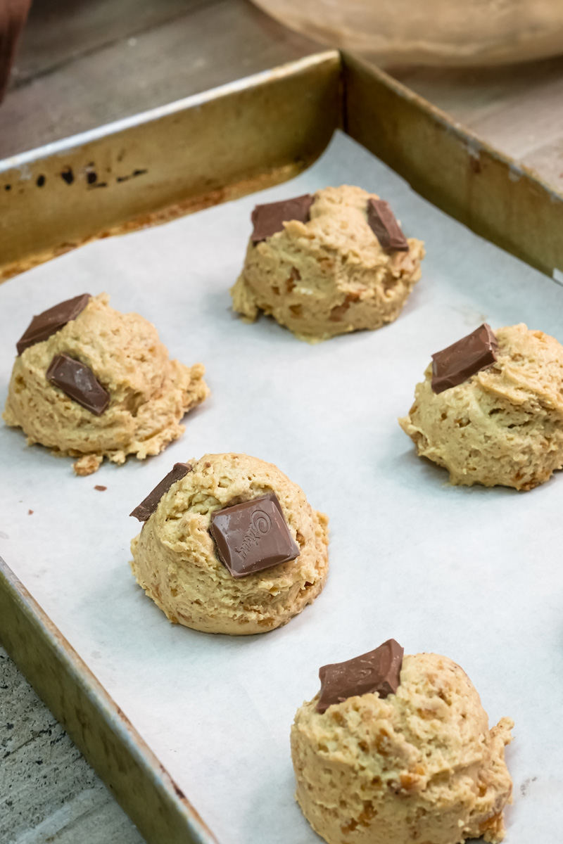 Unbaked s'mores cookies with chocolate pieces on baking sheet