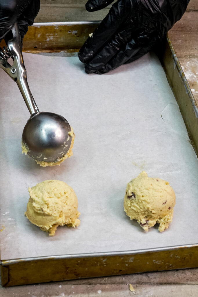 Using a cookie scoop to portion dough onto a baking sheet
