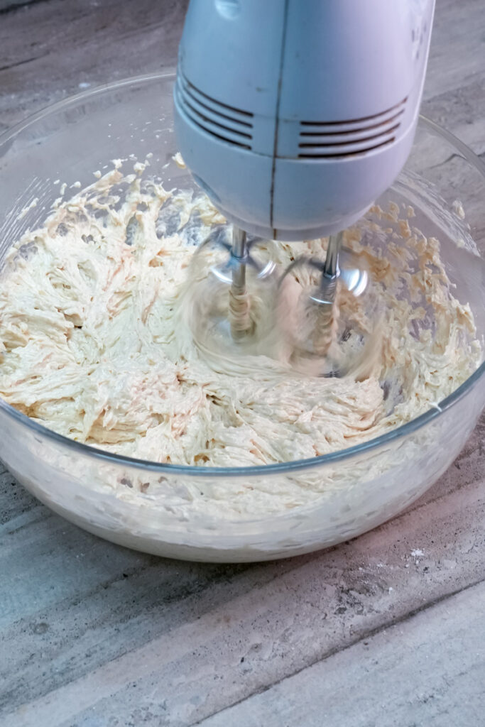 Using a hand mixer to cream butter and sugar