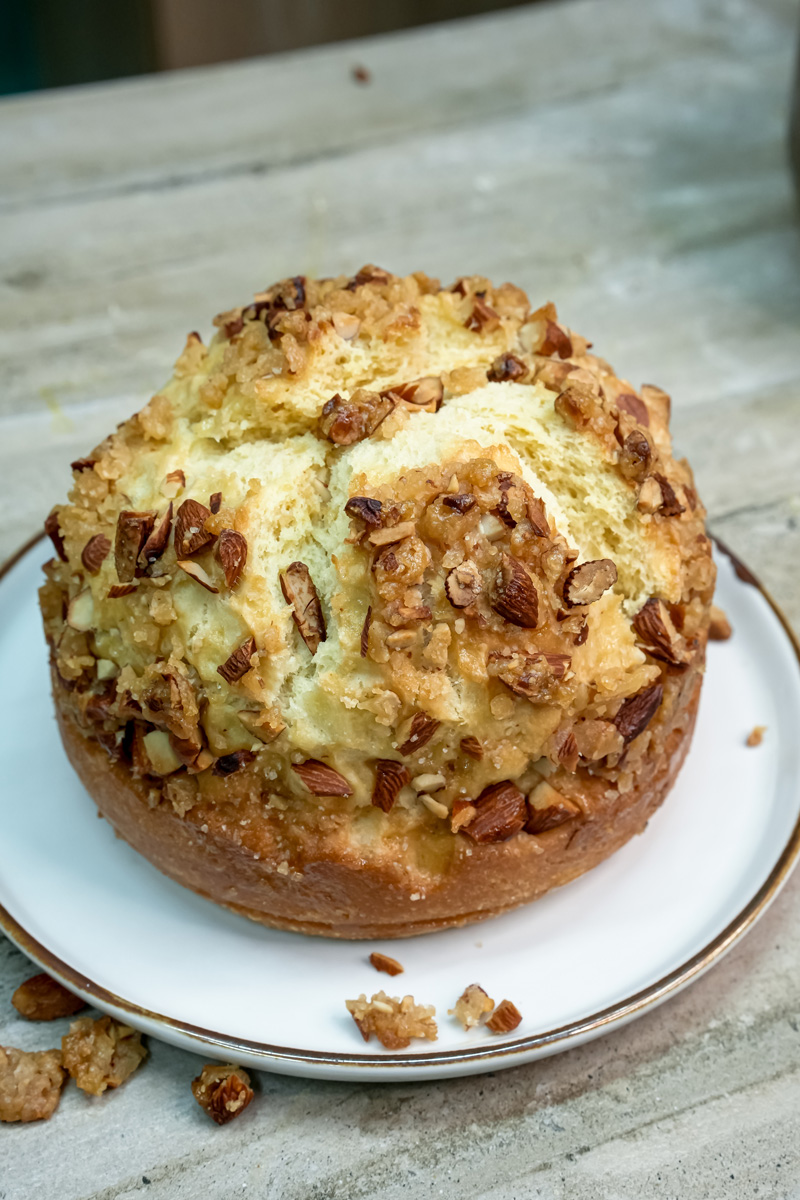Whole bee sting cake with honey almond topping on marble surface