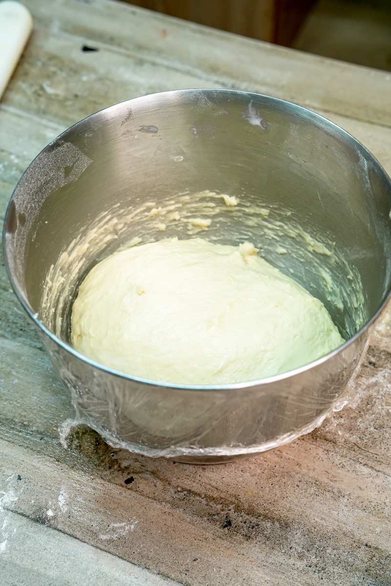 Yeast dough rising in glass mixing bowl for bee sting cake recipe