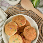 A top-down view of a plate of Funfetti cookies with a glass of milk