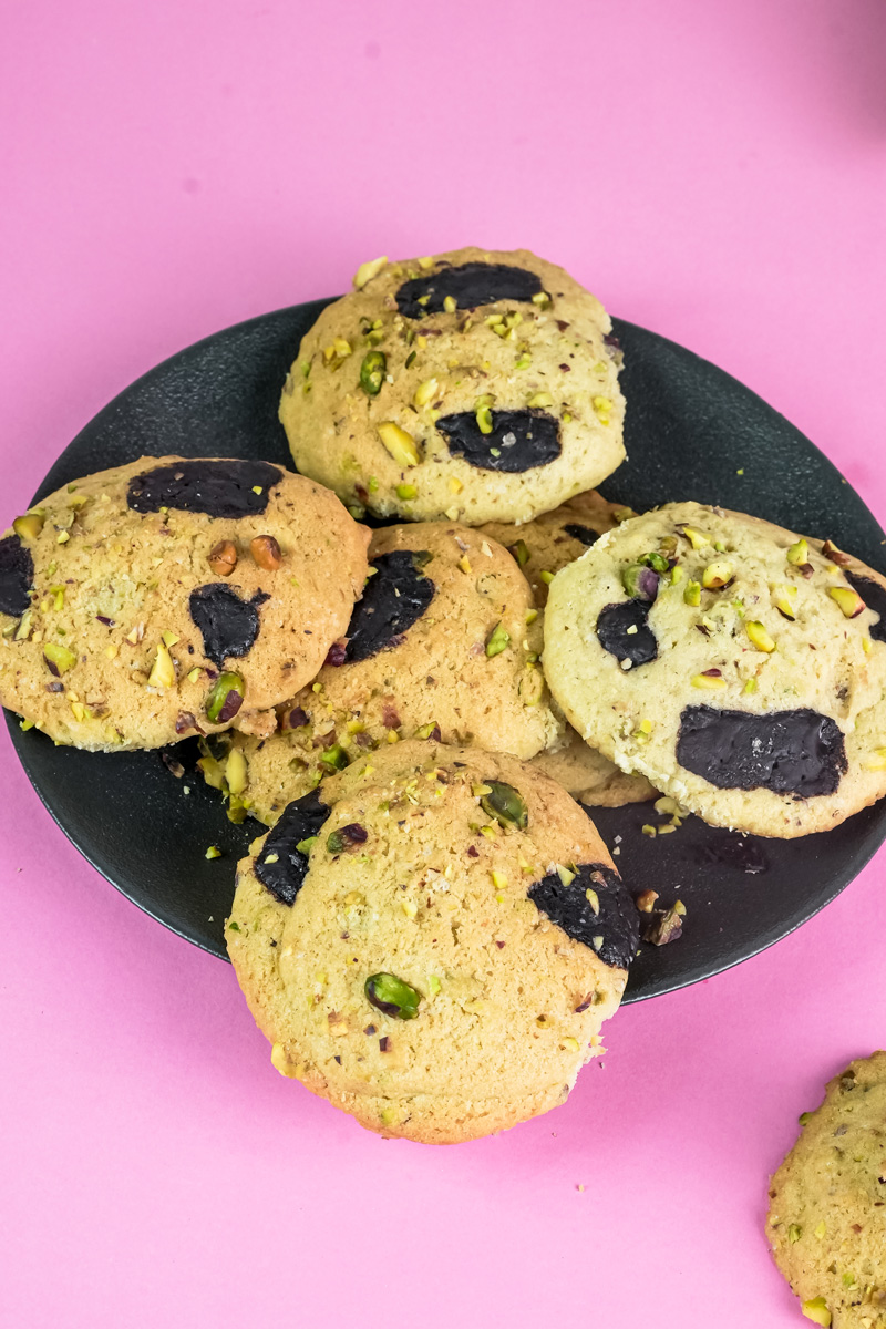 A full plate of baked pistachio and dark chocolate cookies