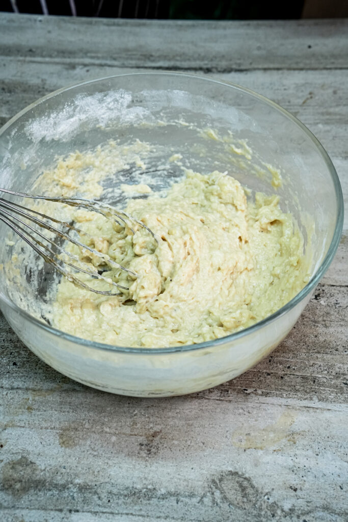 Close-up of the completed banana protein muffin batter in a clear glass bowl