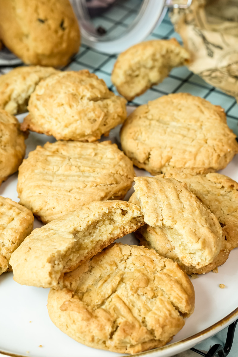  A broken peanut butter cookie on a pile of delicious cookies