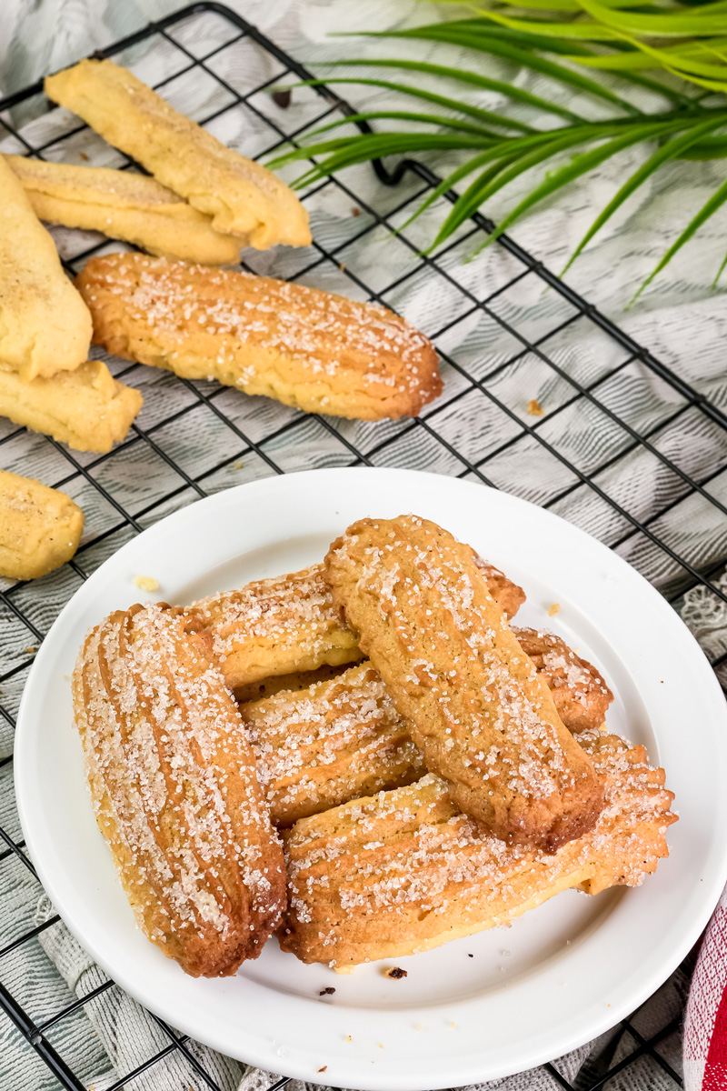 A plate of churro cookies with a sugar coating on a cooling rack, ready to be served.