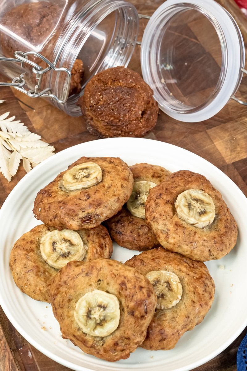 A plate of delicious banana cookies with a jar of cookies in the background