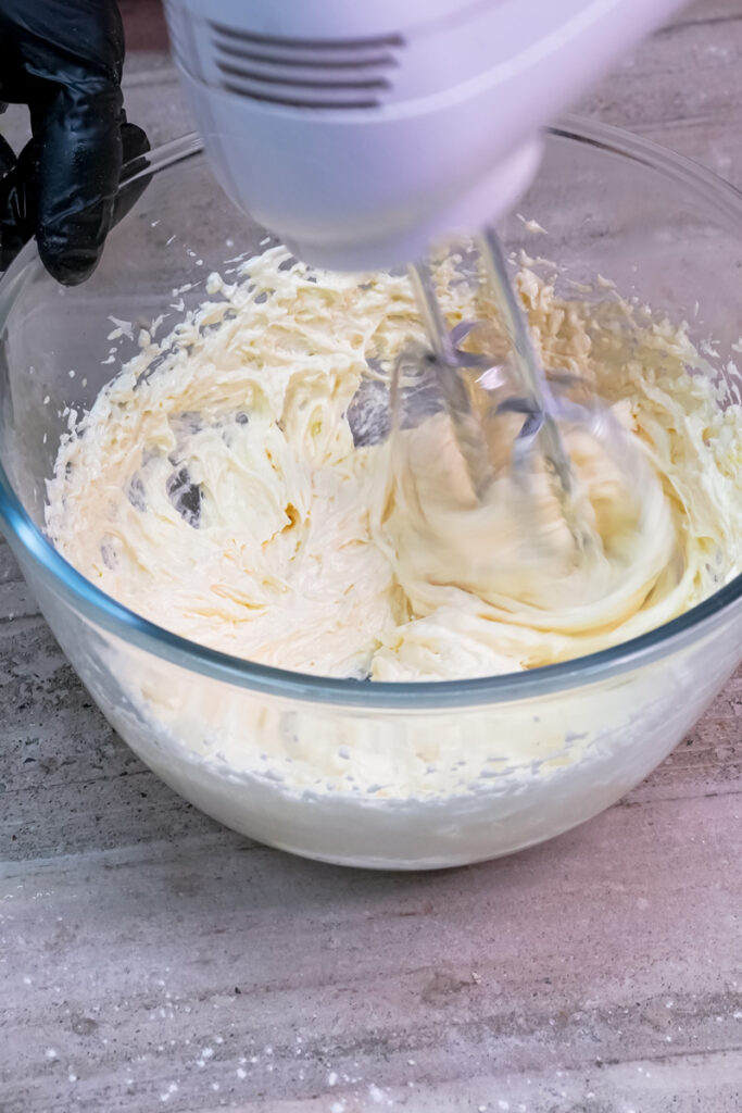 n electric mixer blending the wet ingredients for oatmeal cookies until smooth and fluffy