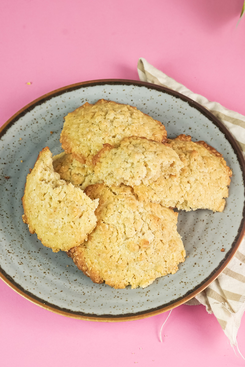 A plate of freshly baked homemade oatmeal cookies, with a few broken open to show the texture