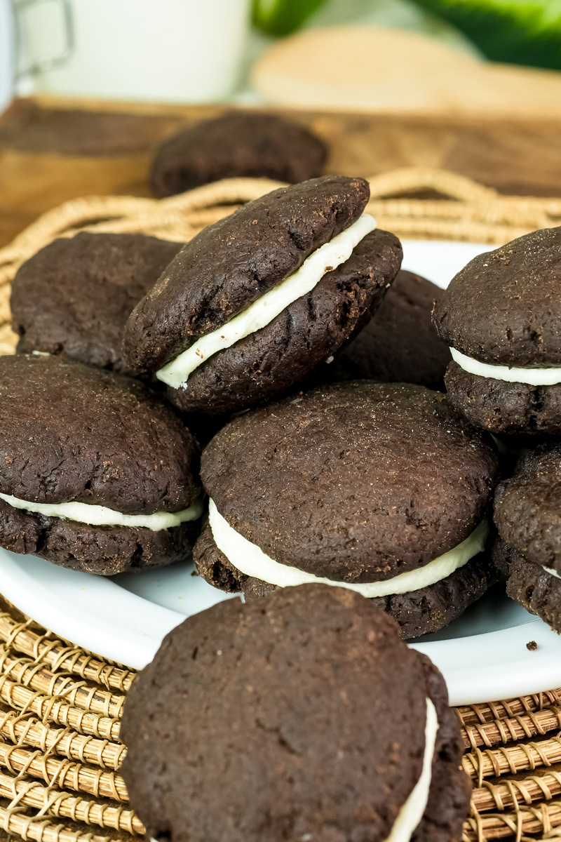 A close-up of a plate of homemade Oreo cookies with creamy filling