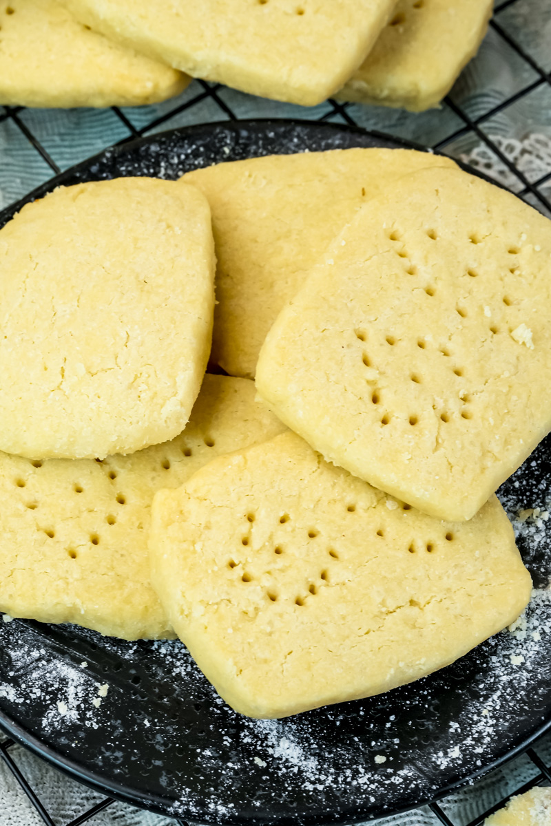 Close-up of shortbread cookies showing crumbly texture on black plate