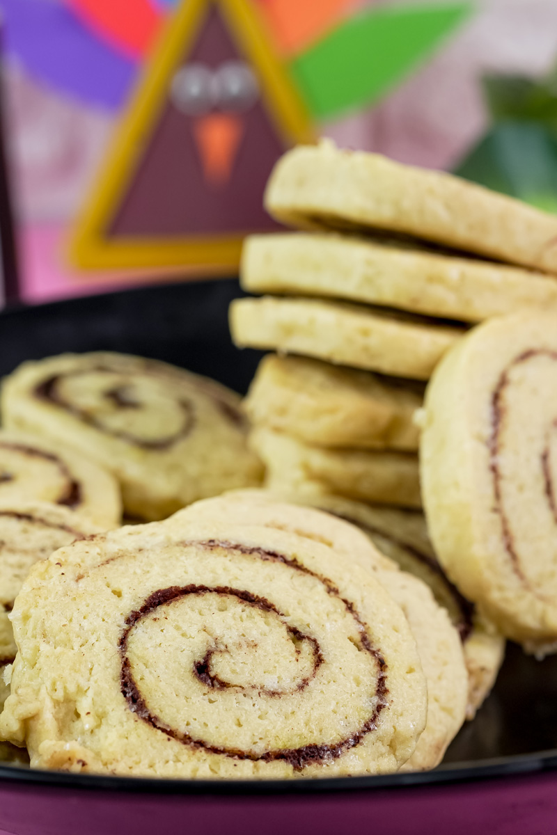 Close-up of a stack of cinnamon roll cookies with a festive background