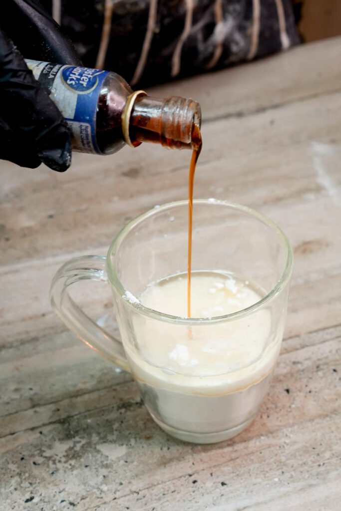 Adding a drop of vanilla extract to the coffee mug cake base