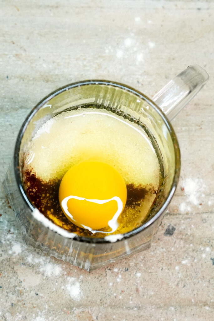 Adding a fresh egg to the keto mug cake ingredients