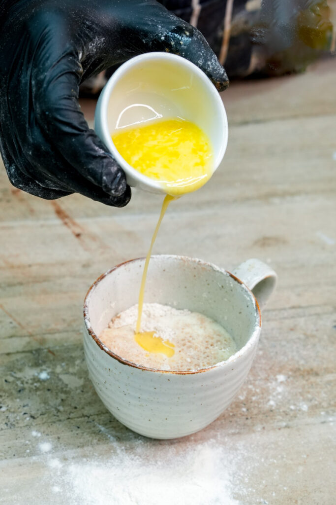 Adding melted butter to the snickerdoodle mug cake batter