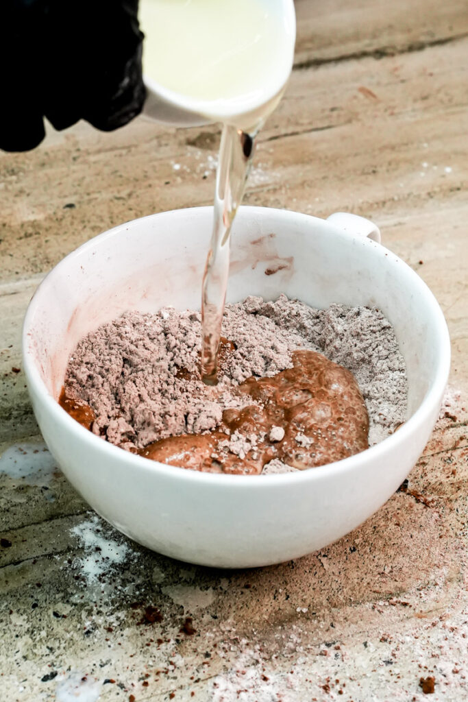 Adding oil to the dry chocolate mug cake mix for a moist, healthy dessert
