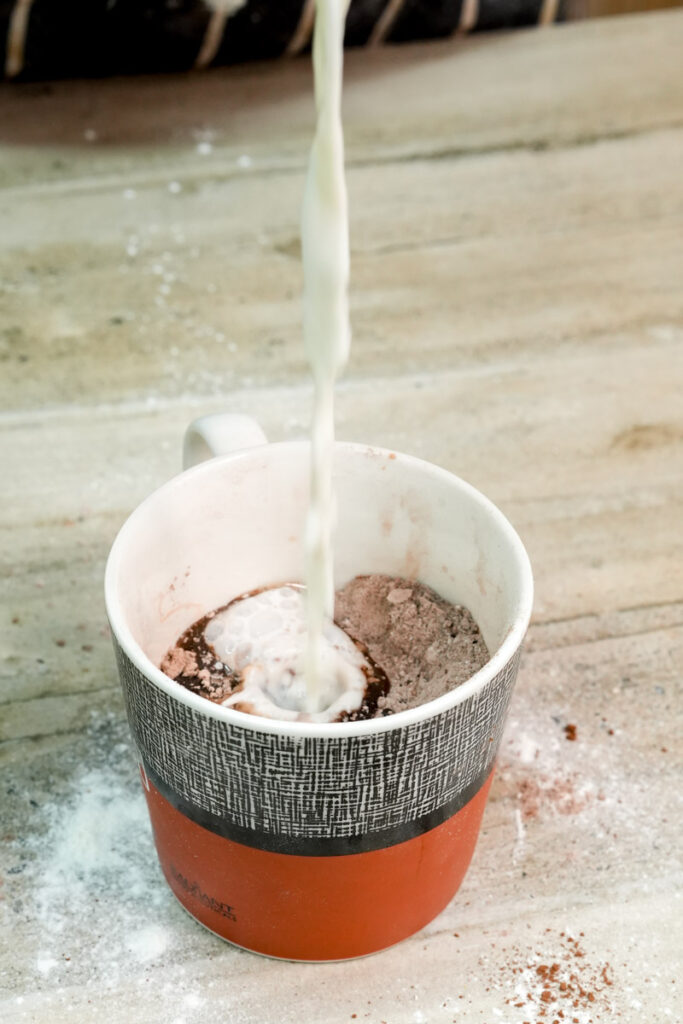 Adding plant-based milk to the chocolate mug cake mix