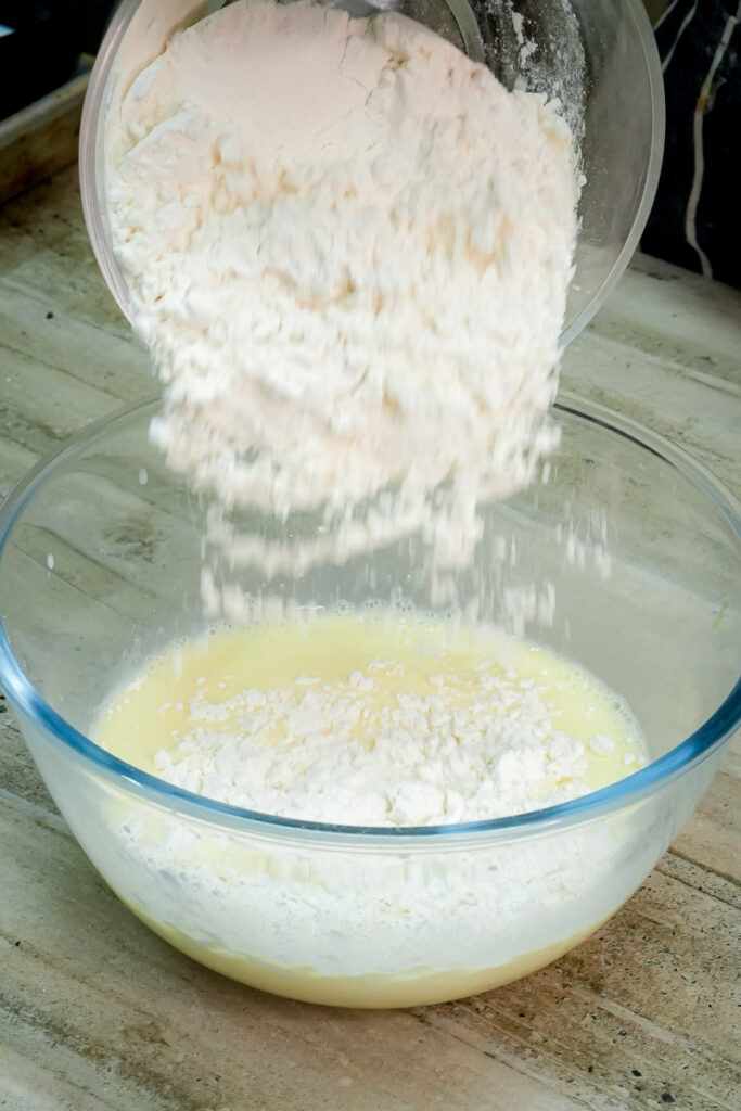 Adding sifted all-purpose flour to the wet pancake ingredients