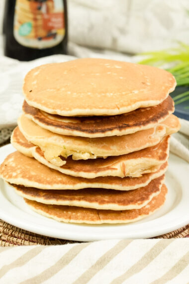 Close-up of a tall stack of fluffy golden brown American pancakes.