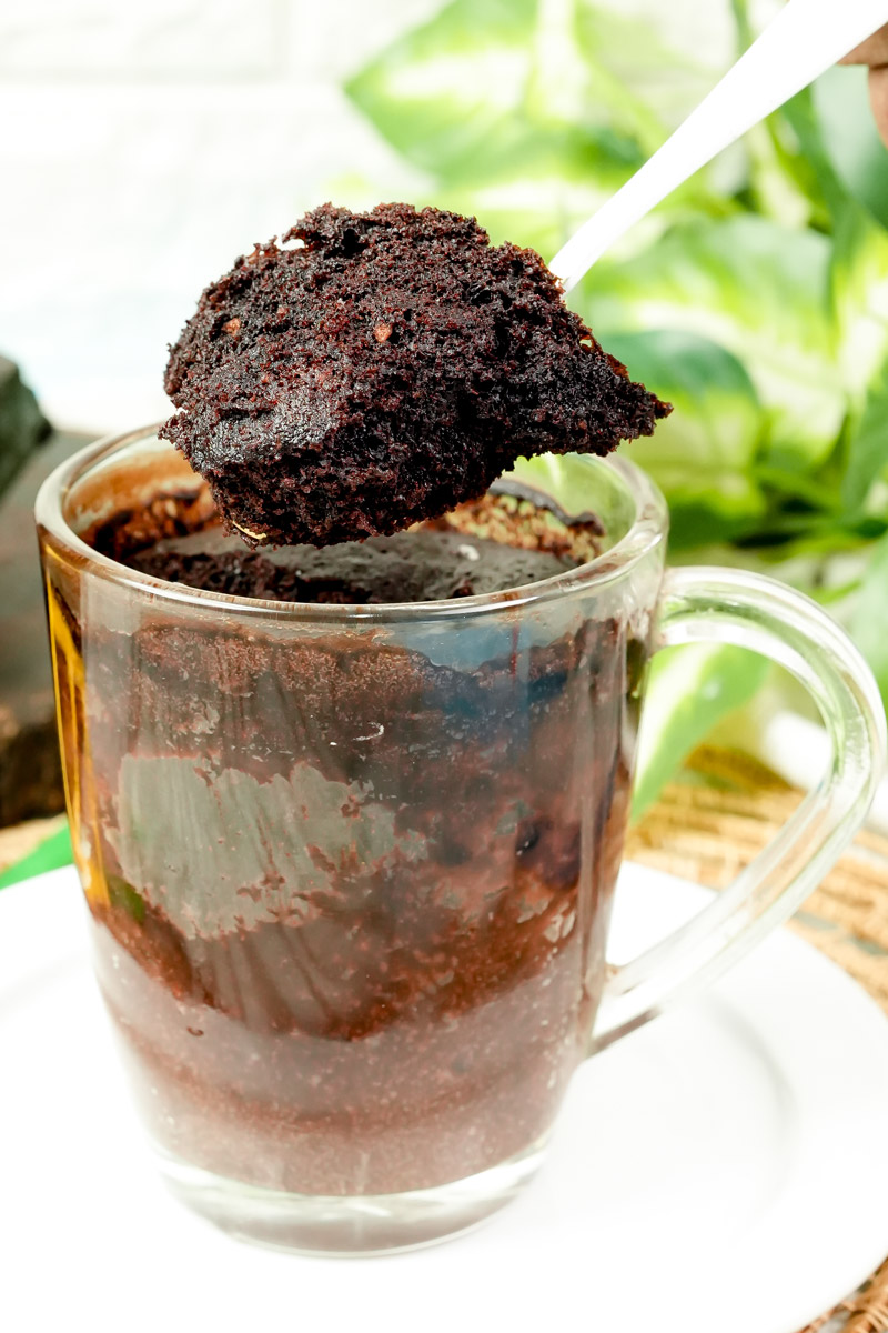 Fluffy chocolate gluten-free mug cake bite held up on a spoon