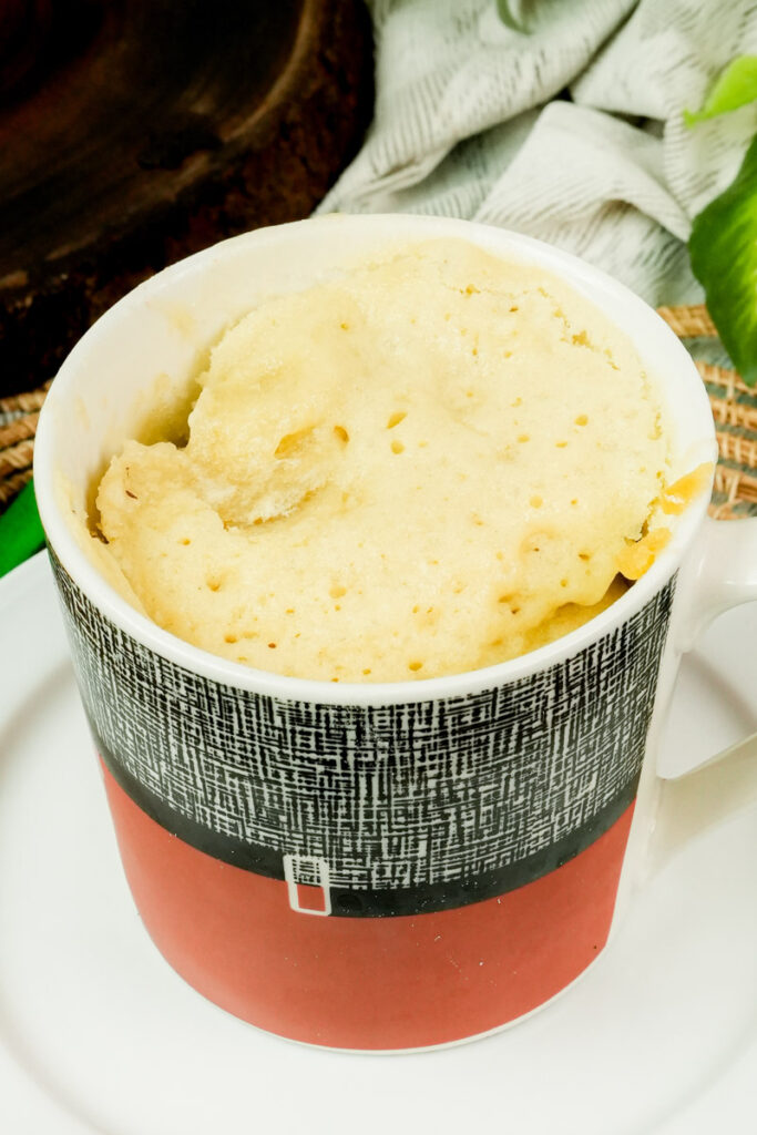 Freshly baked fluffy vanilla mug cake in a ceramic mug