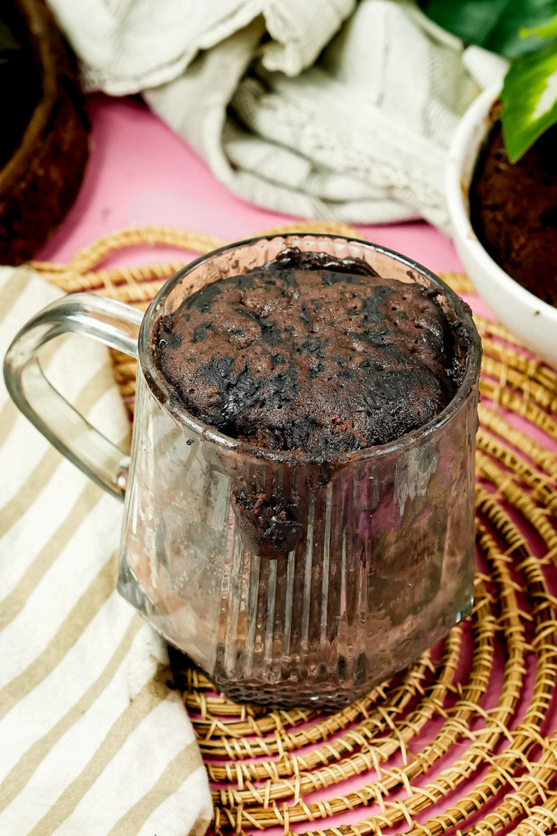 Freshly baked keto chocolate mug cake in a clear glass mug