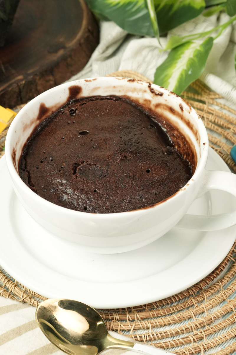 Freshly baked low calorie chocolate mug cake in a white ceramic cup