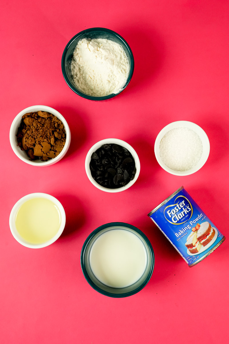 Ingredients for low calorie chocolate mug cake including flour, cocoa powder, milk, and baking powder