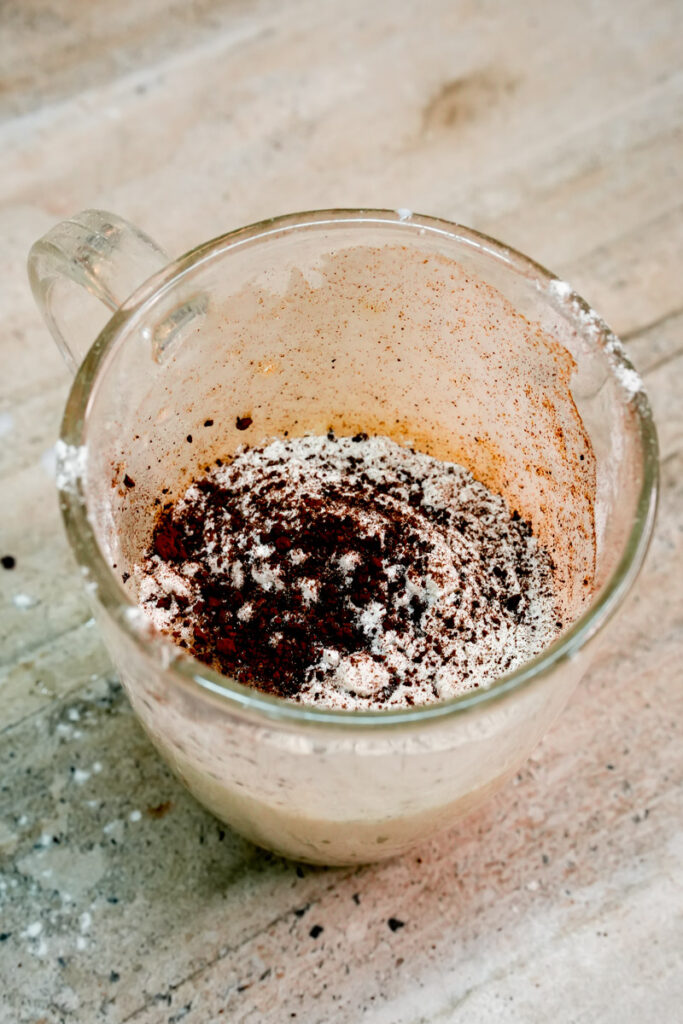 Instant coffee granules sprinkled over flour for a mocha mug cake