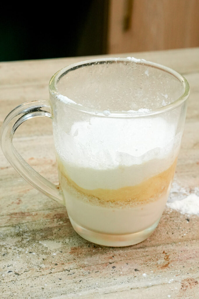 Layers of wet and dry mug cake ingredients before mixing