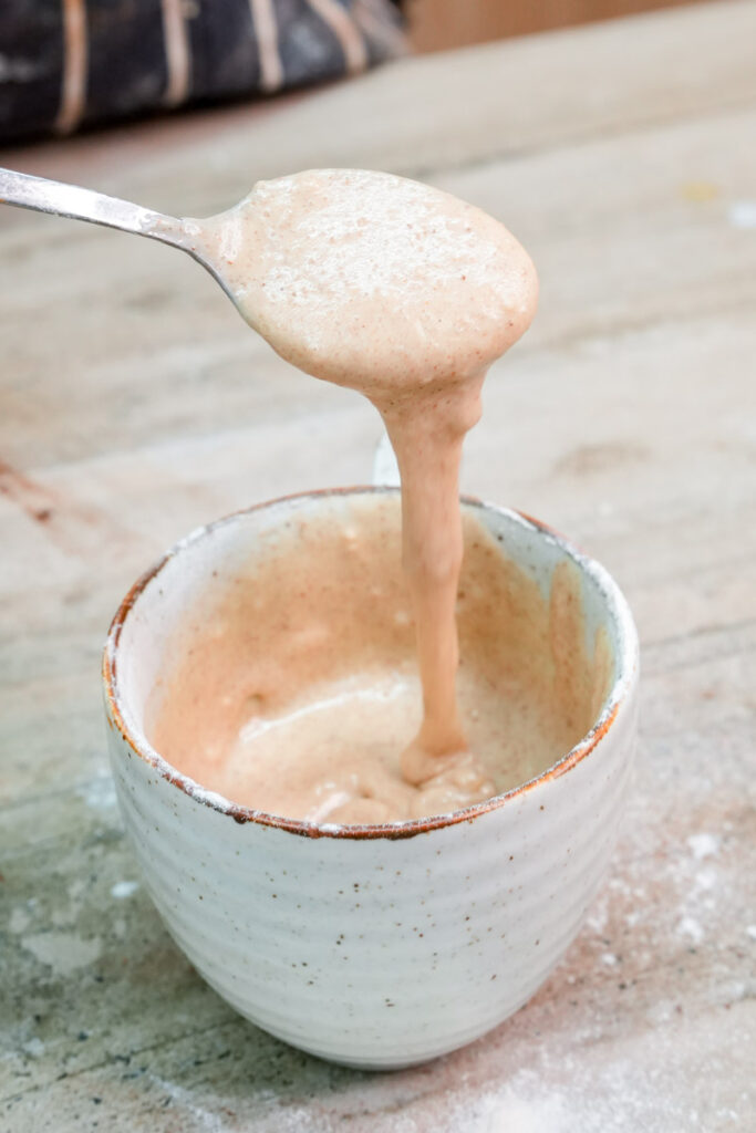 Lifting a spoon of smooth snickerdoodle mug cake batter to show consistency