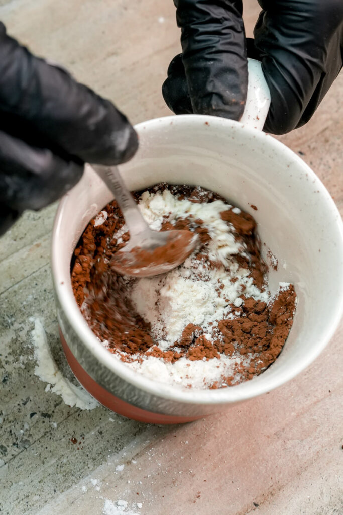 Mixing dry ingredients for a chocolate mug cake with a spoon
