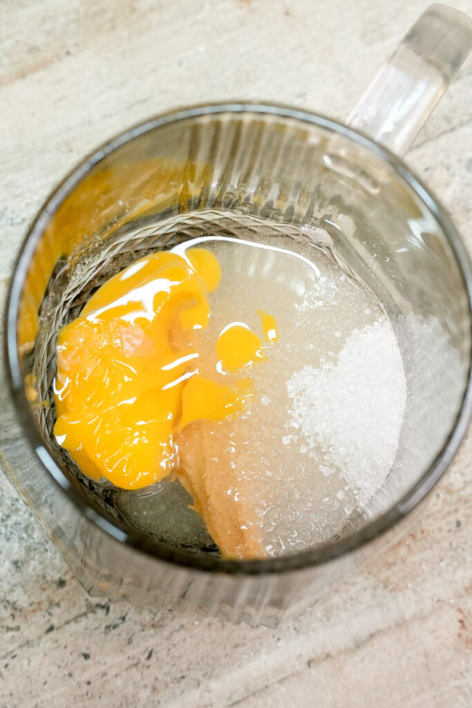 Mixing egg, sugar, and peanut butter in a mug for a single-serve cake