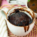 Finished Nutella mug cake served on a pink surface with a gold fork