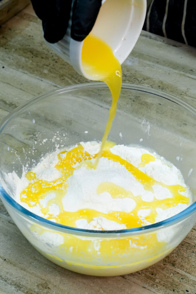 Pouring melted butter into the pancake flour mixture