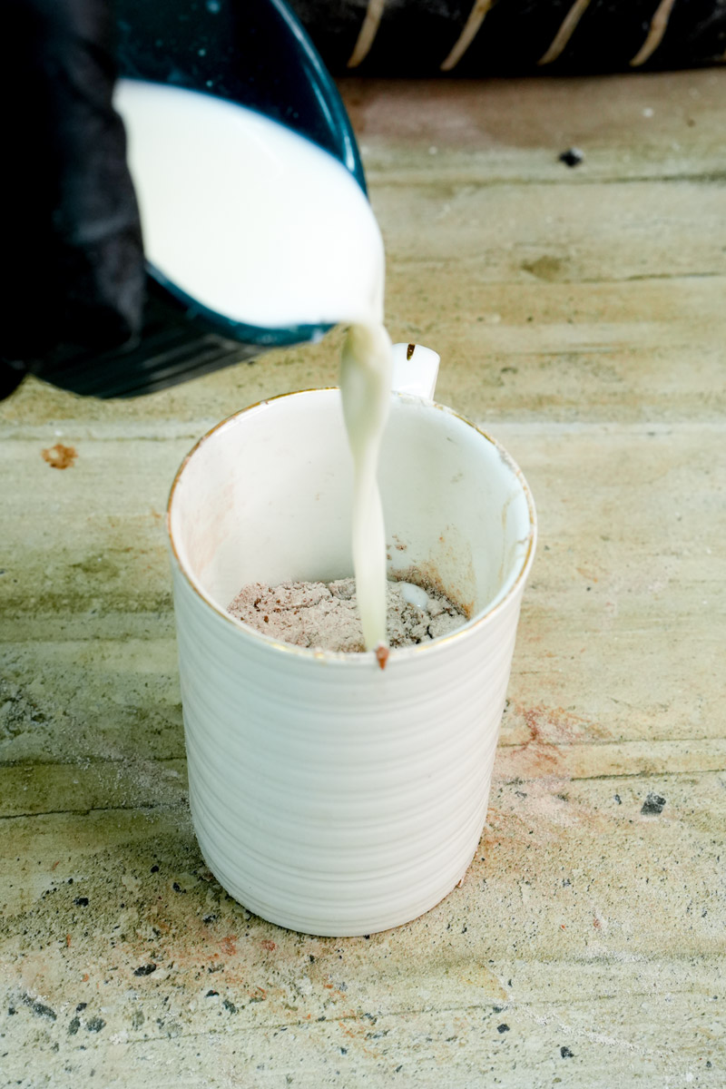 Pouring milk into the dry mug cake ingredients