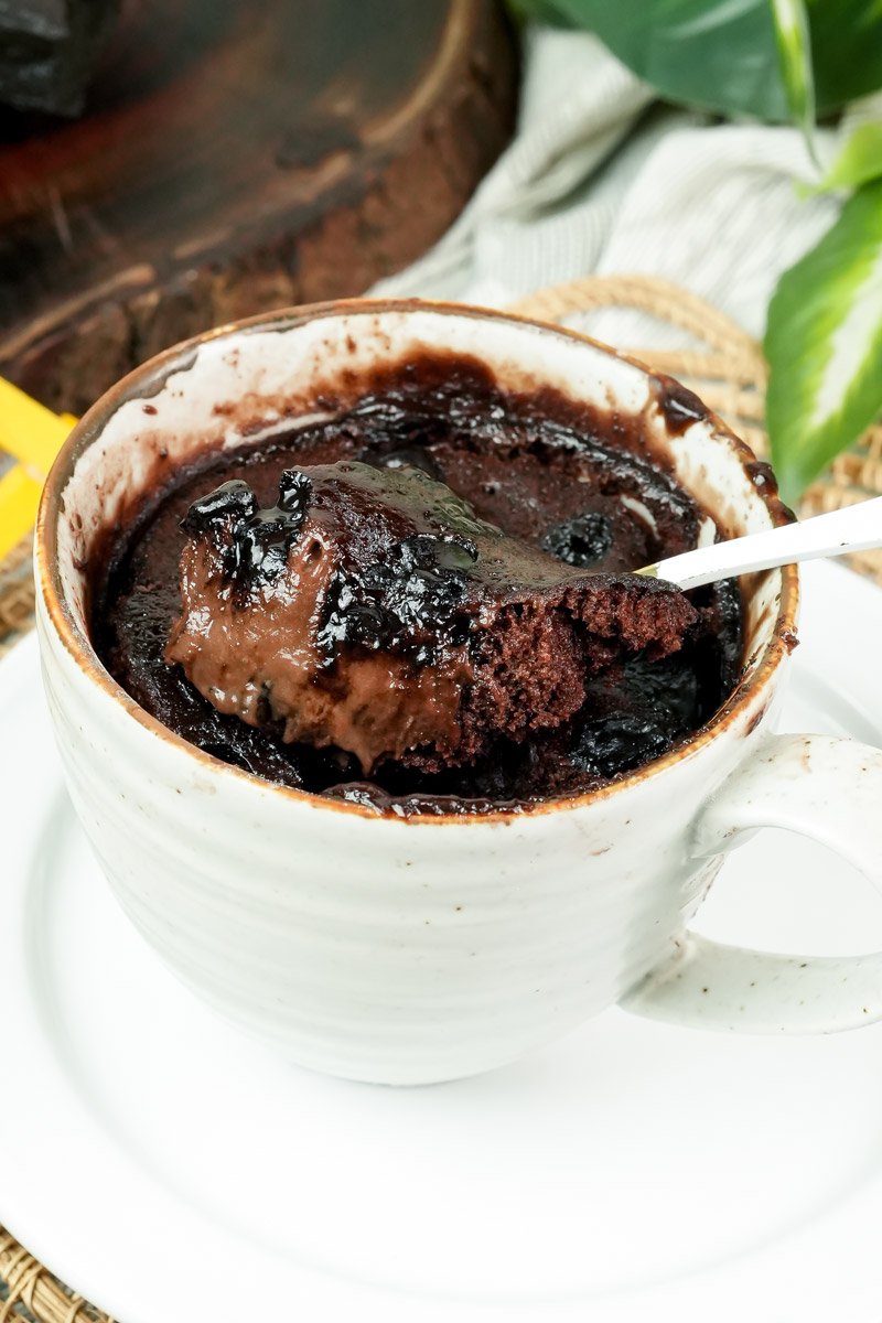 Scoop of gooey chocolate brownie in a mug showing melted center