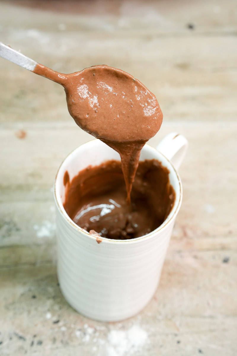 Thick chocolate protein cake batter on a spoon