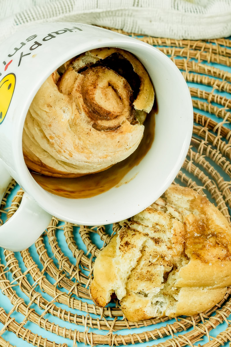 Close-up of a fluffy microwave cinnamon roll and a piece of sweet bread