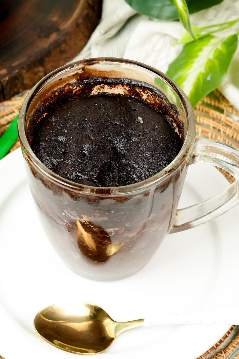 Finished gluten-free mug cake with a gold spoon on the side