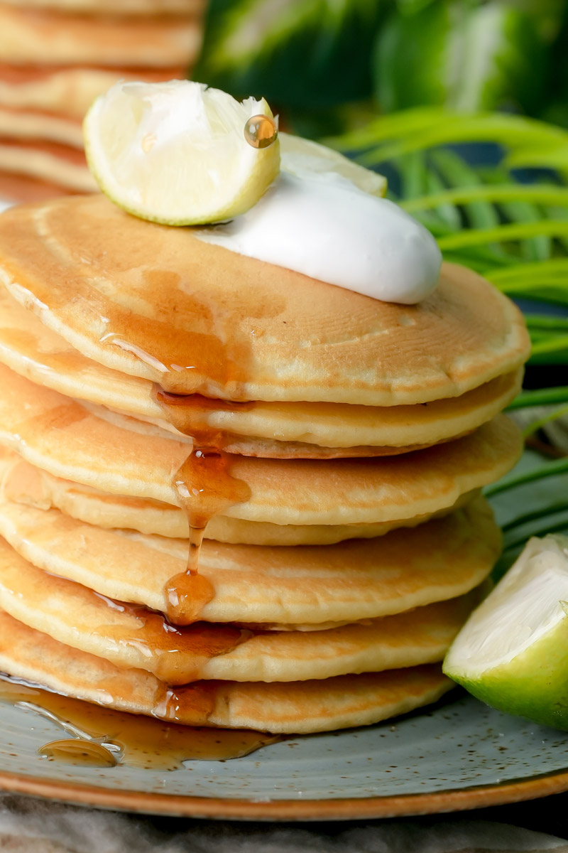 Macro shot of maple syrup glistenning on the edges of fluffy lemon pancakes