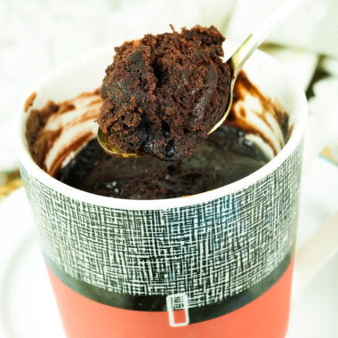 Close-up of a bite-sized piece of moist vegan chocolate cake on a gold spoon