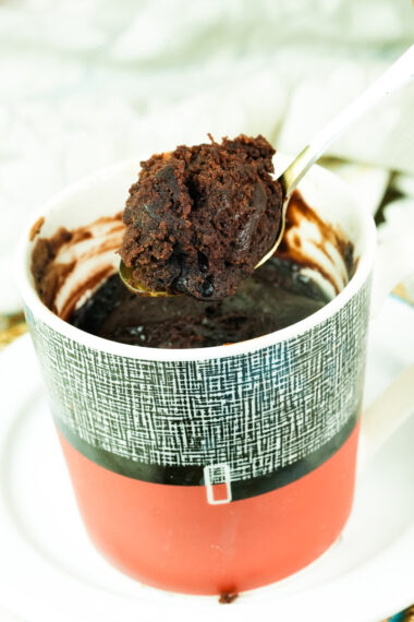 Close-up of a bite-sized piece of moist vegan chocolate cake on a gold spoon