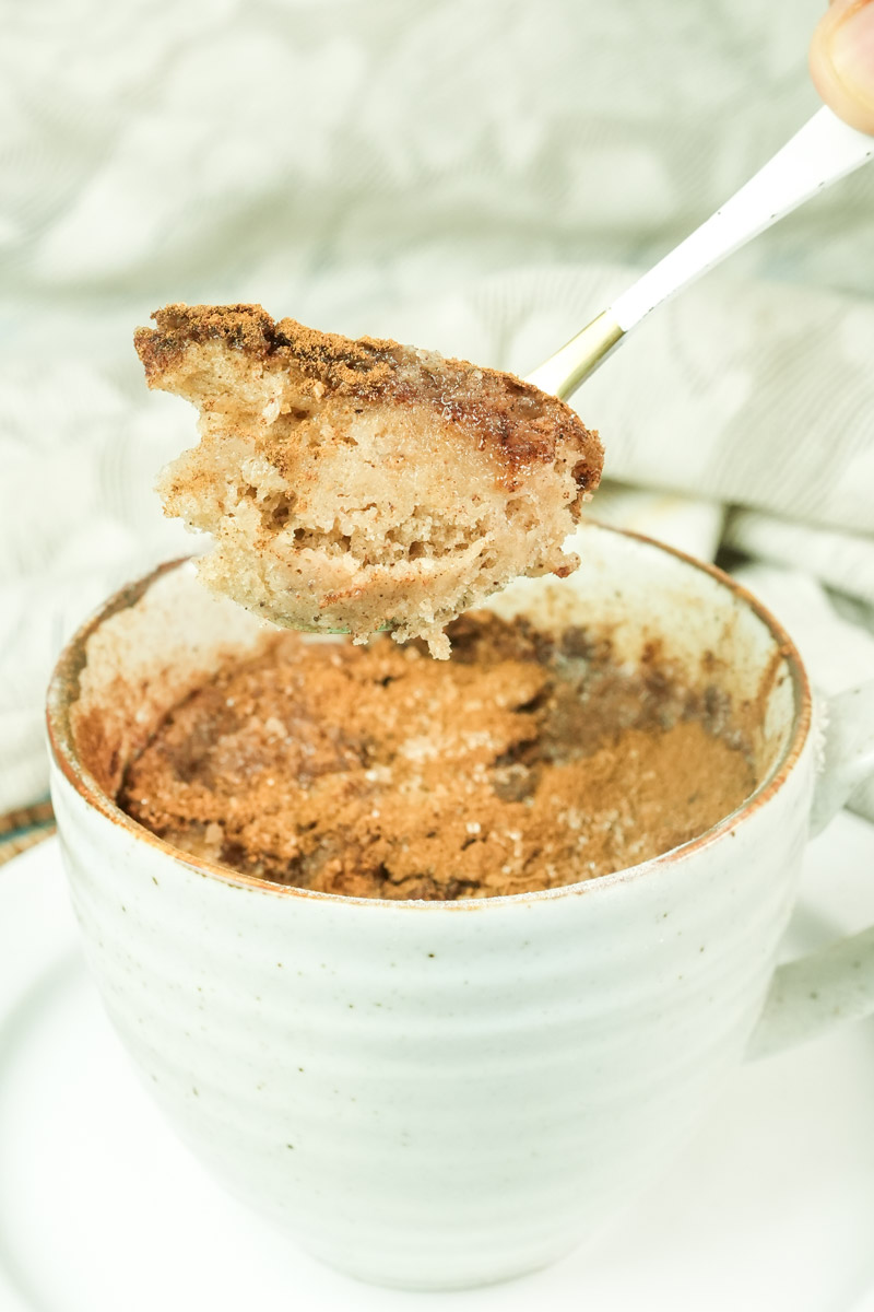 Close-up of a bite-sized piece of snickerdoodle cake on a gold spoon