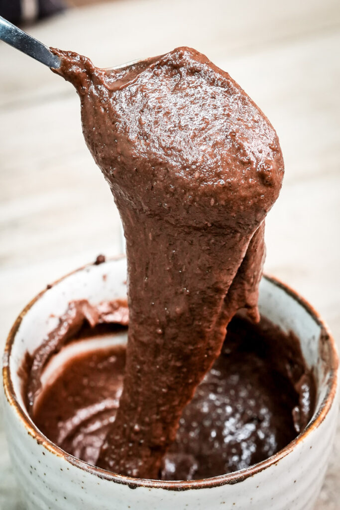 Close up of a spoonful of moist, low calorie chocolate mug cake showing the fudgy texture