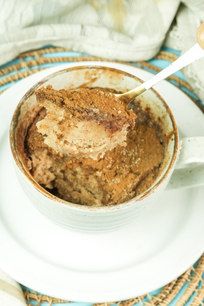 High-angle shot of a spoonful of moist snickerdoodle mug cake showing the soft interior